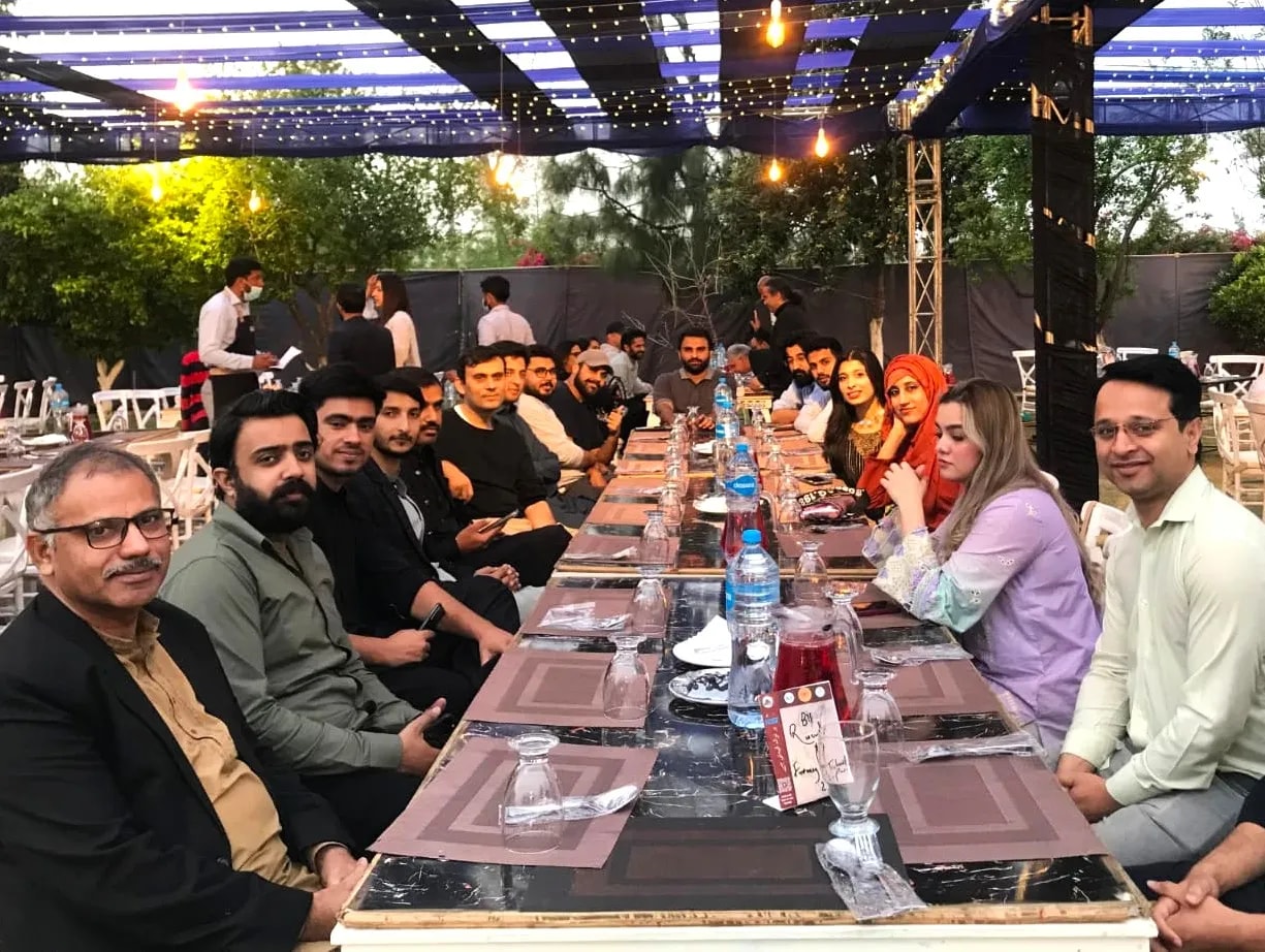 The team seated along a long table for an iftar dinner