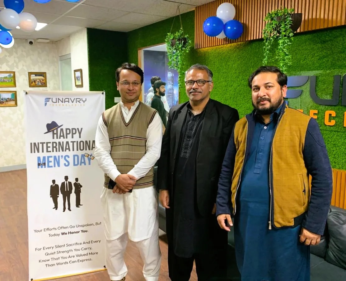 Colleagues beside an International Men's Day banner at the office